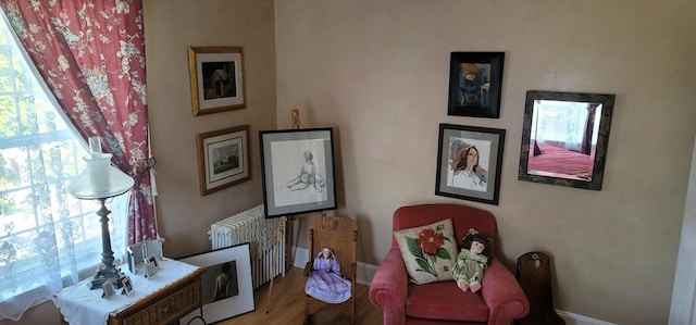 sitting room featuring radiator heating unit and hardwood / wood-style flooring