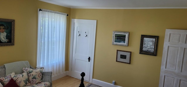 living area featuring light hardwood / wood-style floors and crown molding