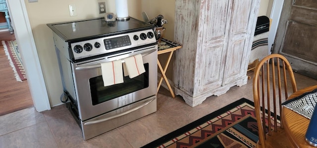 kitchen with tile patterned floors and stainless steel electric range oven