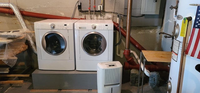 clothes washing area with electric panel, washer and clothes dryer, and gas water heater