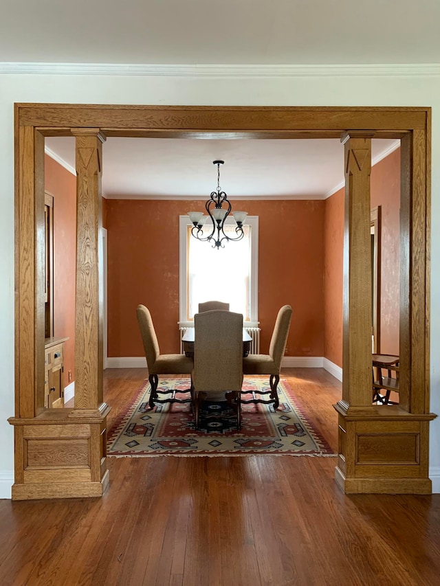 dining area featuring hardwood / wood-style floors, ornamental molding, and decorative columns