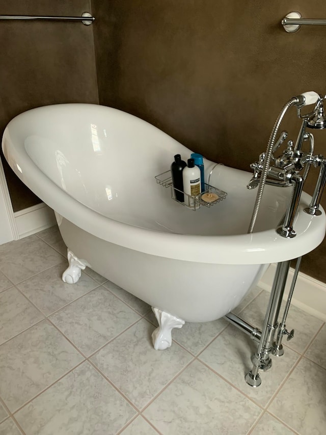 bathroom with a tub to relax in and tile patterned floors