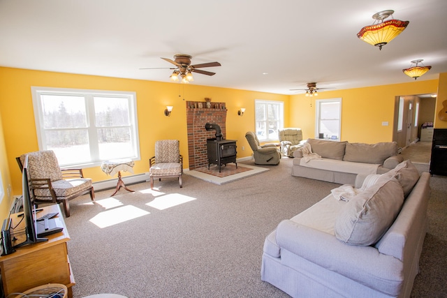 living room with carpet flooring, ceiling fan, and a wood stove