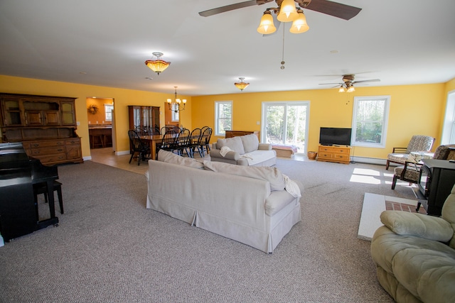 living room with light carpet, ceiling fan with notable chandelier, and a baseboard heating unit