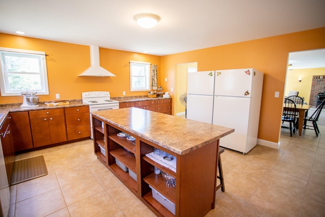 kitchen with a center island, white appliances, a kitchen breakfast bar, light tile patterned floors, and range hood