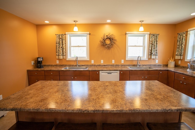 kitchen with a breakfast bar area, a wealth of natural light, and sink