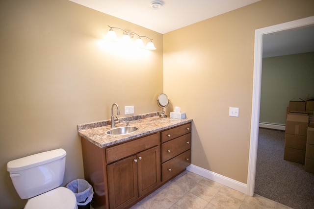 bathroom with tile patterned flooring, vanity, a baseboard heating unit, and toilet