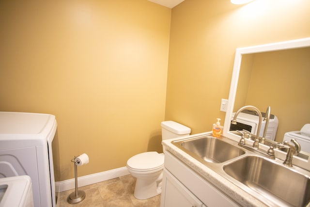 bathroom with tile patterned floors, toilet, washer / dryer, and vanity