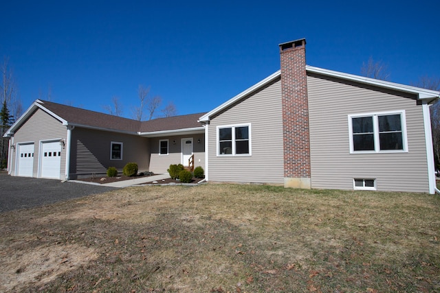 single story home with a garage and a front lawn