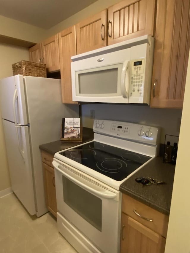 kitchen featuring white appliances and light brown cabinetry