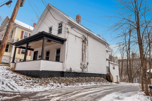 snow covered property with a porch