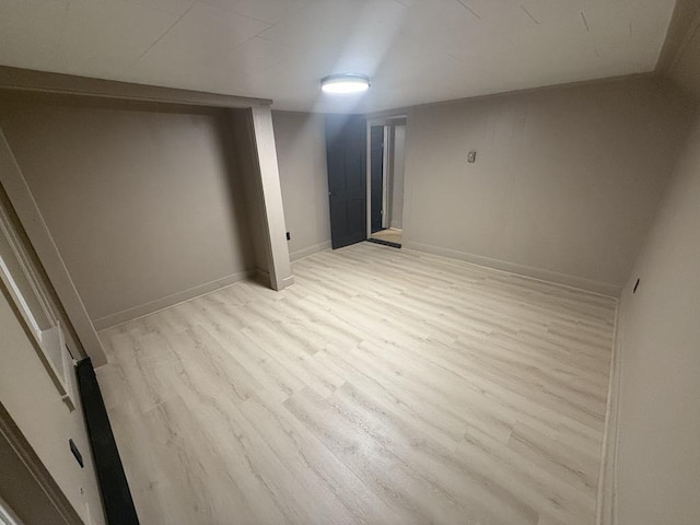 basement with light hardwood / wood-style flooring