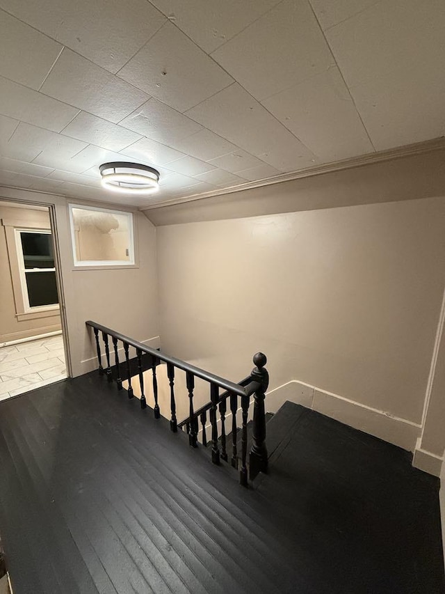 staircase with built in features and wood-type flooring