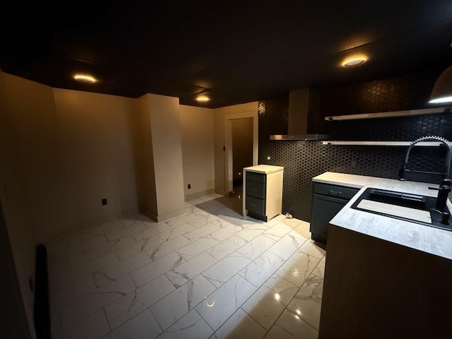 kitchen featuring wall chimney range hood and sink