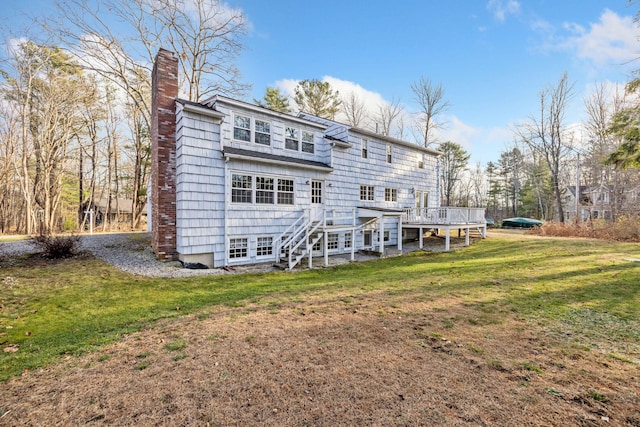 rear view of house with a deck and a yard