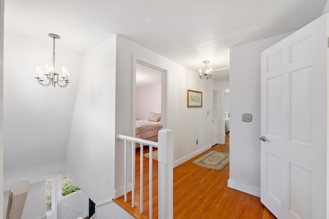 hall featuring hardwood / wood-style floors and a notable chandelier