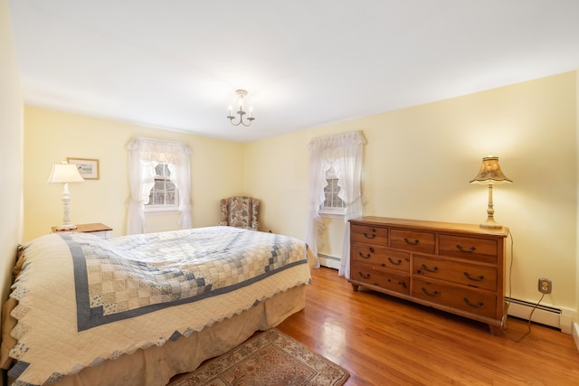 bedroom featuring wood-type flooring and a baseboard radiator