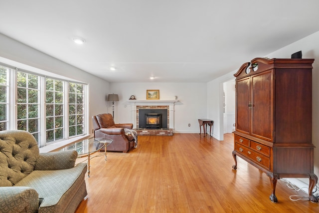 living room featuring a brick fireplace and light hardwood / wood-style flooring