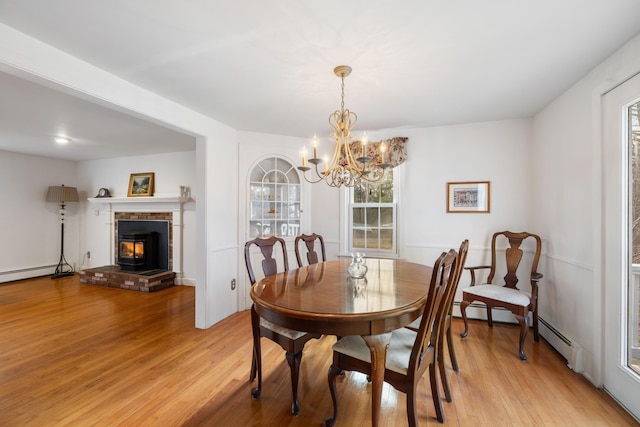 dining room featuring light hardwood / wood-style flooring, a chandelier, and a baseboard heating unit