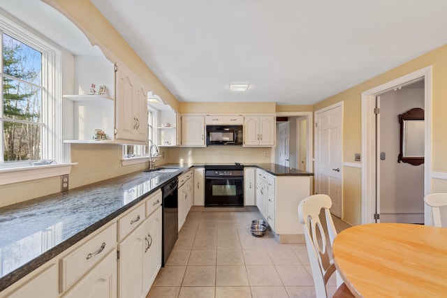 kitchen featuring sink, tasteful backsplash, dark stone counters, light tile patterned flooring, and black appliances