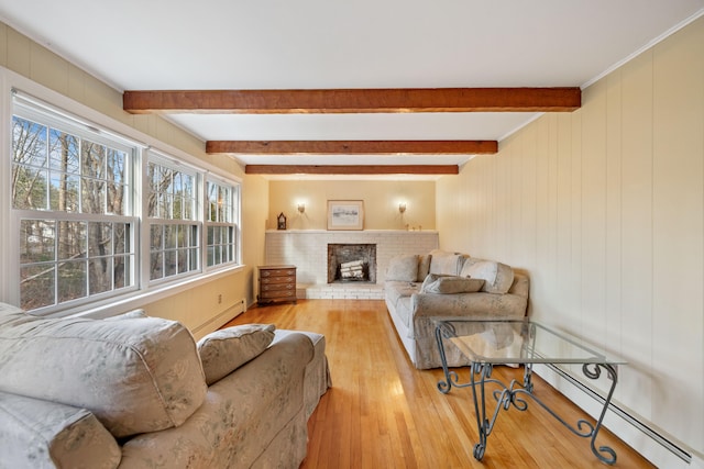 living room with beamed ceiling, light wood-type flooring, a fireplace, and a baseboard heating unit