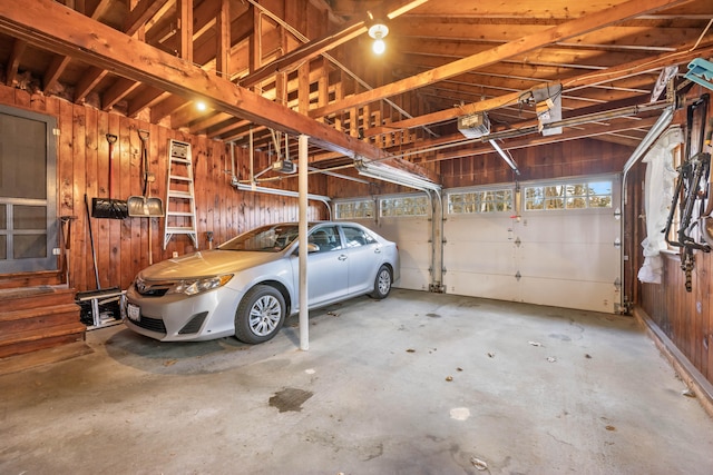 garage featuring wooden walls and a garage door opener