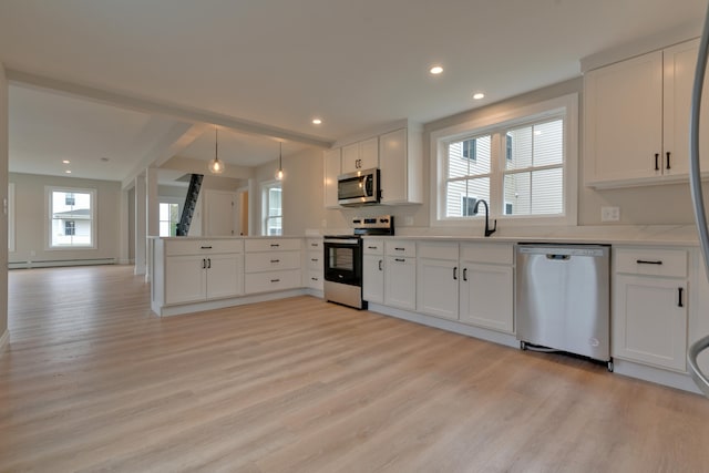 kitchen with a wealth of natural light, white cabinets, and appliances with stainless steel finishes