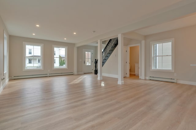 unfurnished living room featuring light hardwood / wood-style flooring and a baseboard heating unit