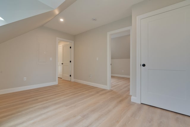 bonus room with electric panel, light hardwood / wood-style floors, and lofted ceiling