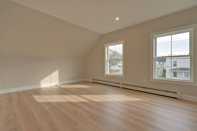 bonus room with light hardwood / wood-style flooring, a baseboard radiator, and vaulted ceiling