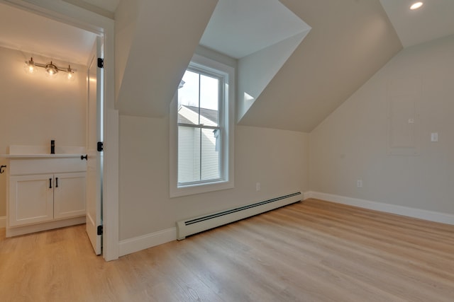 bonus room with light hardwood / wood-style floors, lofted ceiling, and a baseboard heating unit