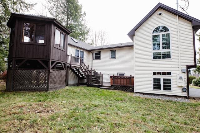 back of house featuring a lawn and a deck