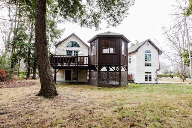 rear view of property featuring a yard and a wooden deck