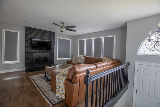 living room featuring ceiling fan, dark wood-type flooring, and a brick fireplace