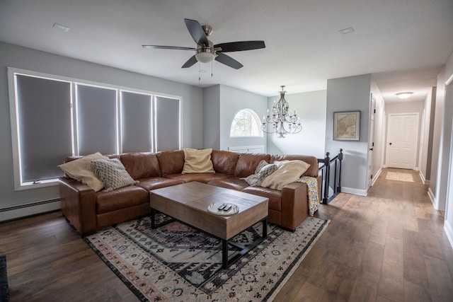 living room featuring ceiling fan with notable chandelier, baseboard heating, and dark wood-type flooring