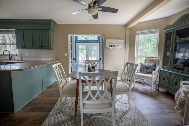 dining area featuring ceiling fan, sink, and dark wood-type flooring