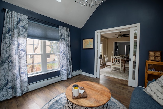 living area featuring ceiling fan, a baseboard heating unit, dark wood-type flooring, and vaulted ceiling