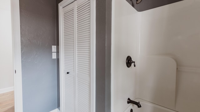 interior space featuring bathtub / shower combination and wood-type flooring