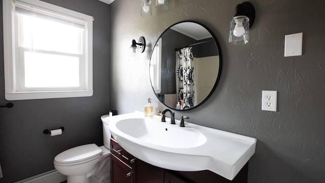 bathroom with a shower with curtain, vanity, toilet, and baseboard heating