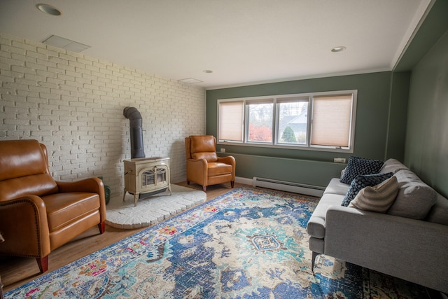 sitting room with ornamental molding, brick wall, a baseboard radiator, hardwood / wood-style floors, and a wood stove