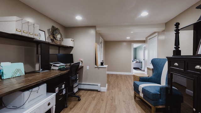 office space with light wood-type flooring and a baseboard heating unit