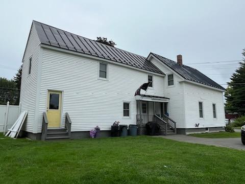 rear view of house featuring a lawn