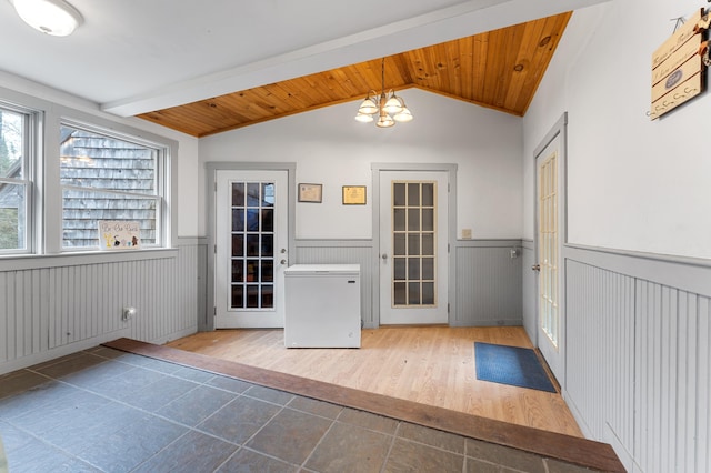 doorway to outside with vaulted ceiling with beams, a chandelier, hardwood / wood-style floors, and wood ceiling