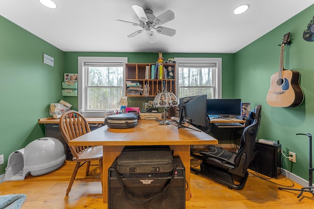 home office with ceiling fan, light hardwood / wood-style flooring, and a healthy amount of sunlight