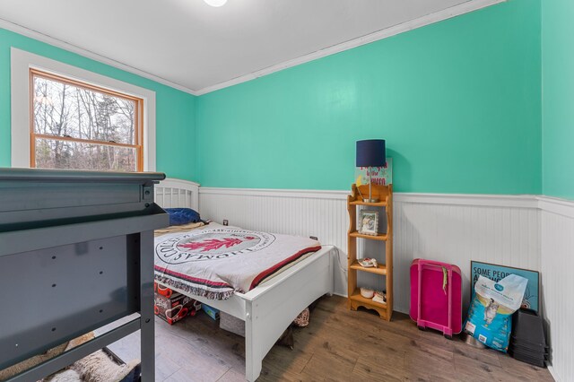 bedroom with wood-type flooring and ornamental molding