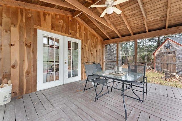 unfurnished sunroom featuring vaulted ceiling with beams, ceiling fan, a wealth of natural light, and french doors