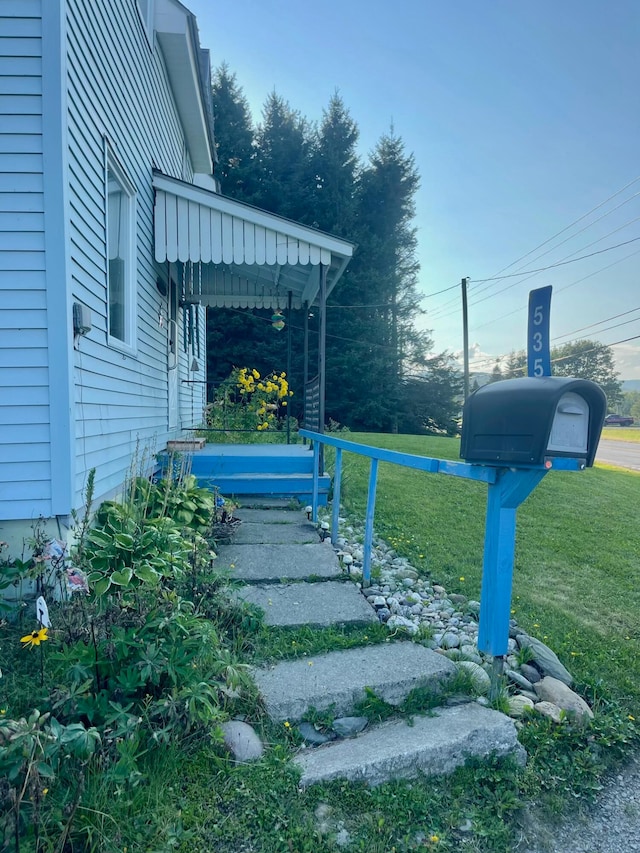 view of exterior entry featuring a lawn