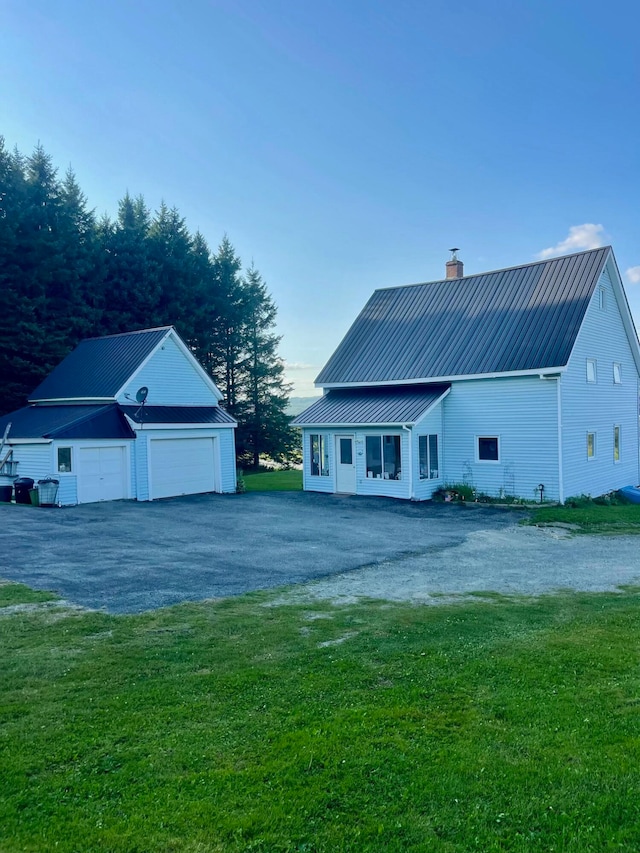 rear view of property with a lawn, a porch, and a garage