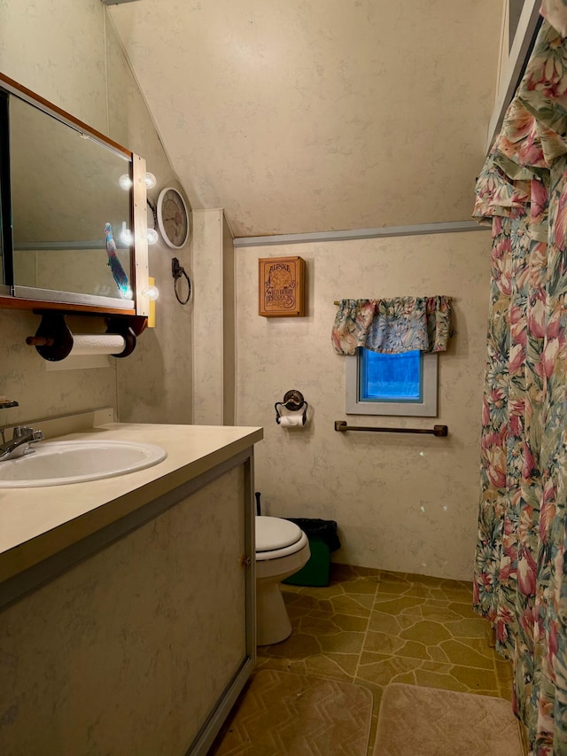 bathroom featuring tile patterned floors, vanity, toilet, and lofted ceiling