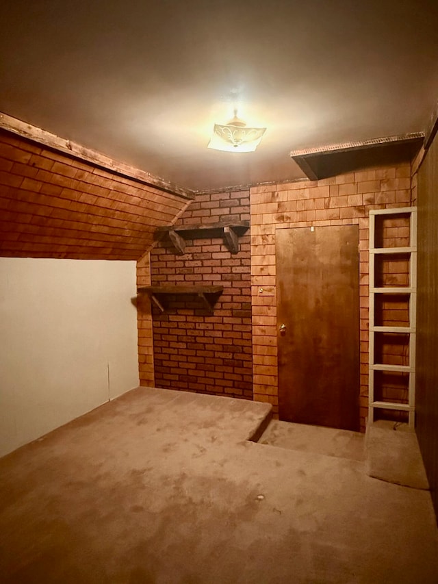 additional living space featuring carpet, brick wall, and vaulted ceiling